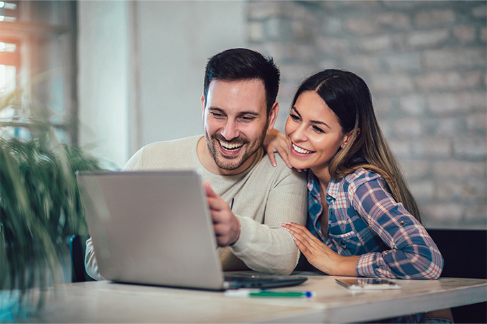 smiling couple looking at computer
