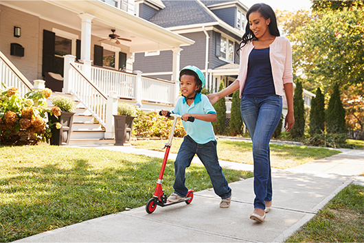 Mother walking with son on sidewalk