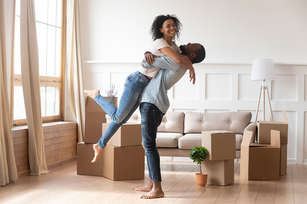 Young couple hugging after receiving an APGFCU mortgage loan
