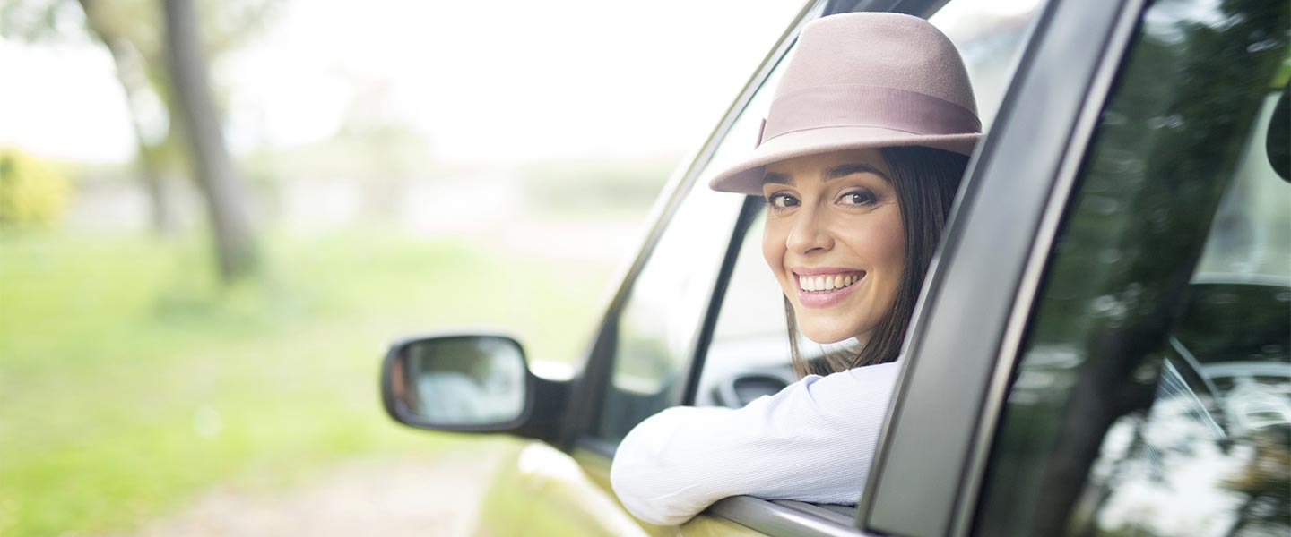 woman in car smiling Auto Loans APGFCU