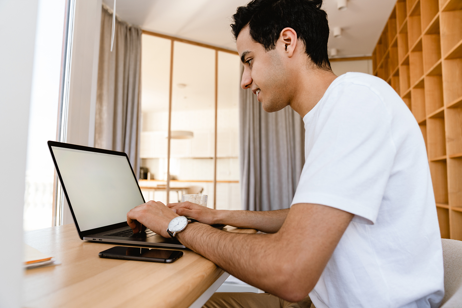 A young man reviews personal loan requirements online using a laptop computer.